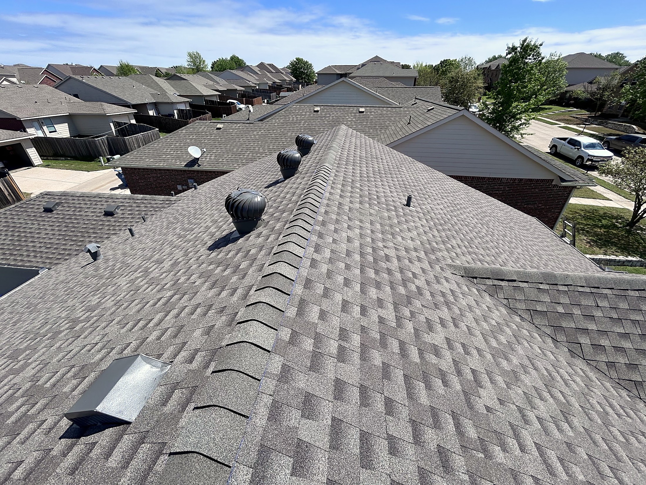 A tall gable and roof valley on a stone home with a new shingle roof