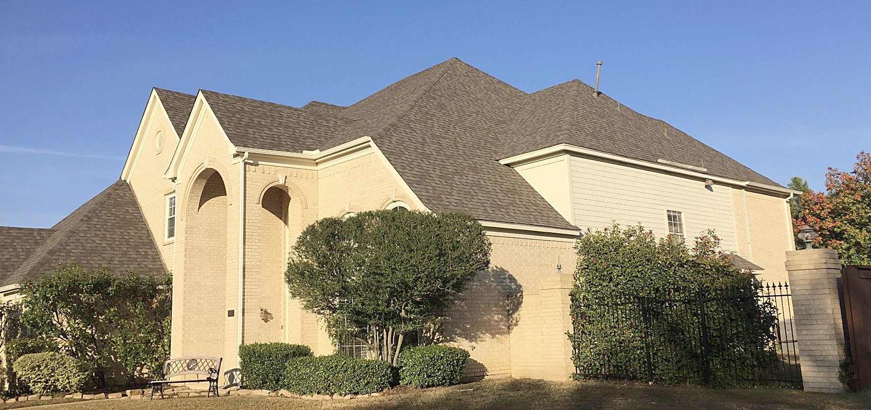The full roofline of a two-story brick home after a shingle replacement
