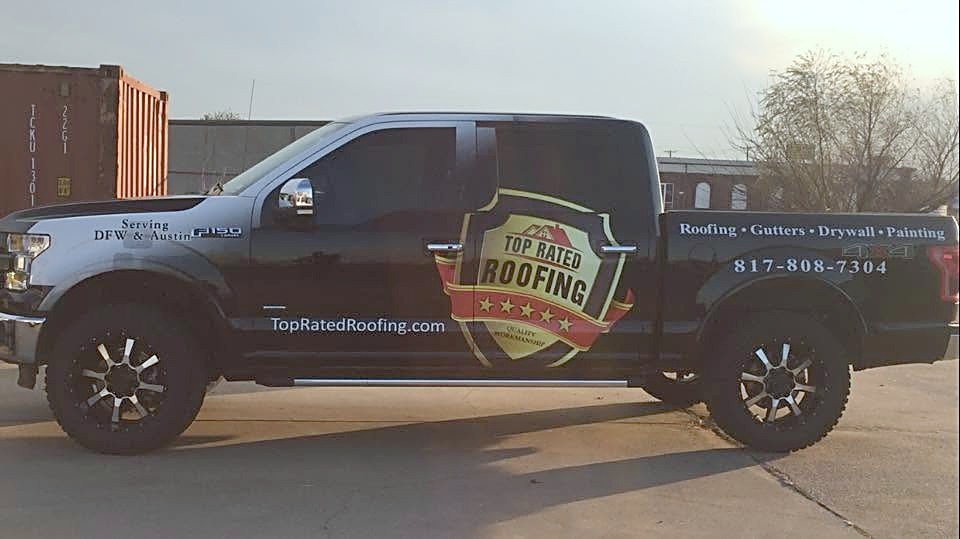 A black Top Rated Roofing pickup truck with the full shield wrap